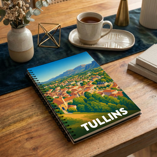Carnet à spirales souvenir de la ville de Tullins avec une illustration stylisée d'un paysage urbain niché au pied des montagnes.
