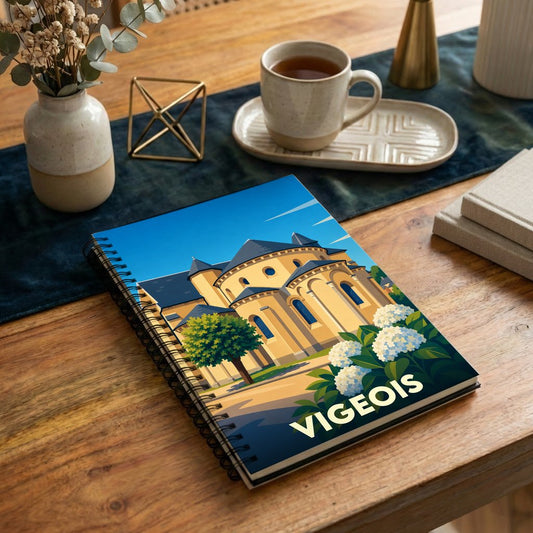 Carnet à spirales souvenir de la ville de Vigeois avec une illustration stylisée de son abbaye.