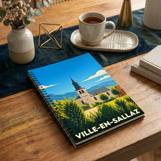 Carnet à spirales souvenir de Ville-en-Sallaz avec une illustration stylisée de son église et d'un paysage ensoleillé.
