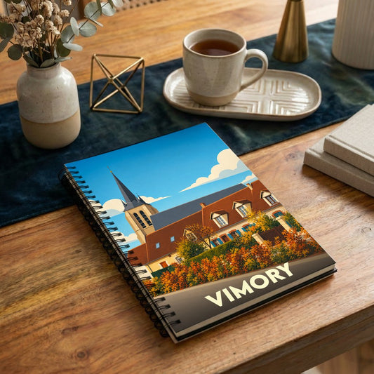 Carnet à spirale souvenir de la ville de Vimory avec une illustration stylisée de son église et ses paysages d'automne.