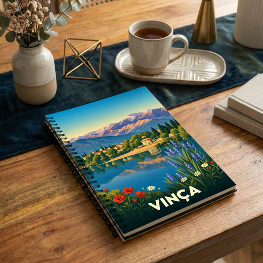 Carnet souvenir de la ville de Vinça avec une illustration stylisée de son lac et des montagnes.