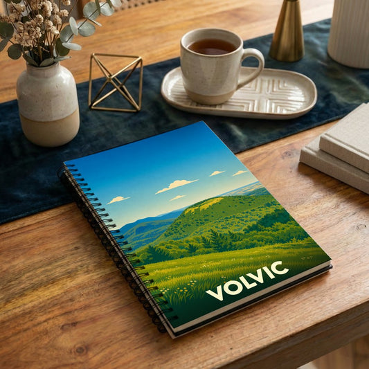 Carnet à spirales souvenir de la ville de Volvic avec une illustration stylisée de paysages volcaniques.