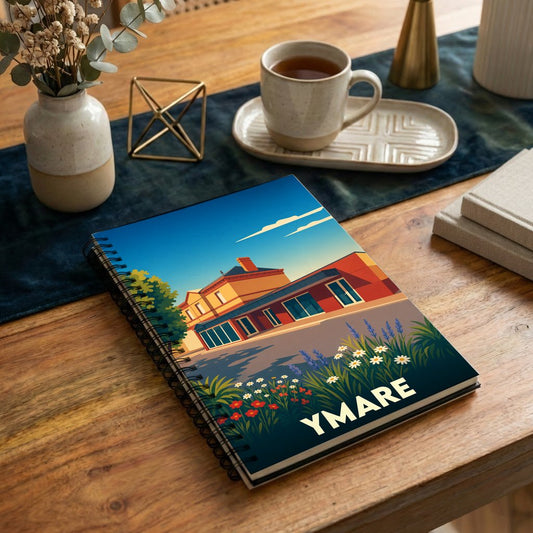 Carnet à spirale souvenir de la ville d'Ymare avec une illustration stylisée d'un paysage urbain fleuri.