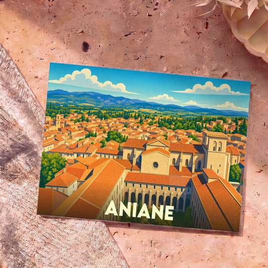 Carte postale souvenir de la ville d'Aniane avec une illustration stylisée montrant une vue aérienne de l'abbaye et des toits du village.
