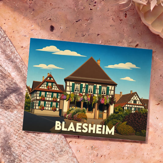 Carte postale souvenir de la ville de Blaesheim avec une illustration stylisée de maisons à colombages fleuries.