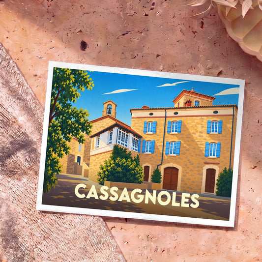 Carte postale souvenir de la ville de Cassagnoles illustrant un village pittoresque aux façades en pierre et volets bleus sous un ciel dégagé.