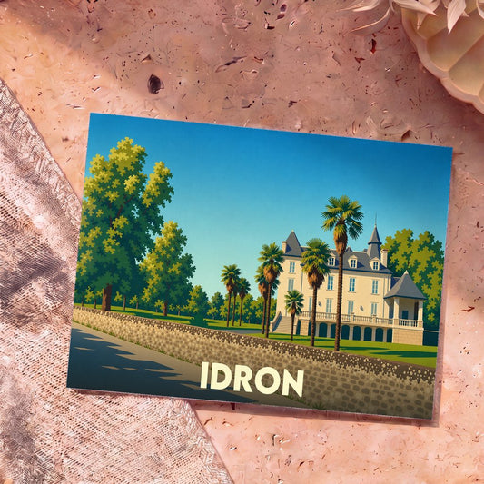 Carte postale souvenir de la ville d'Idron avec une illustration stylisée de son château et de palmiers.