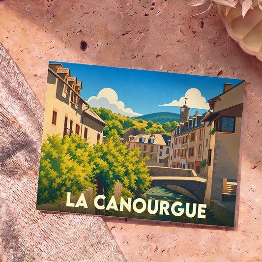 Carte postale souvenir de la ville de La Canourgue avec une illustration stylisée d'un pont et de bâtiments colorés.