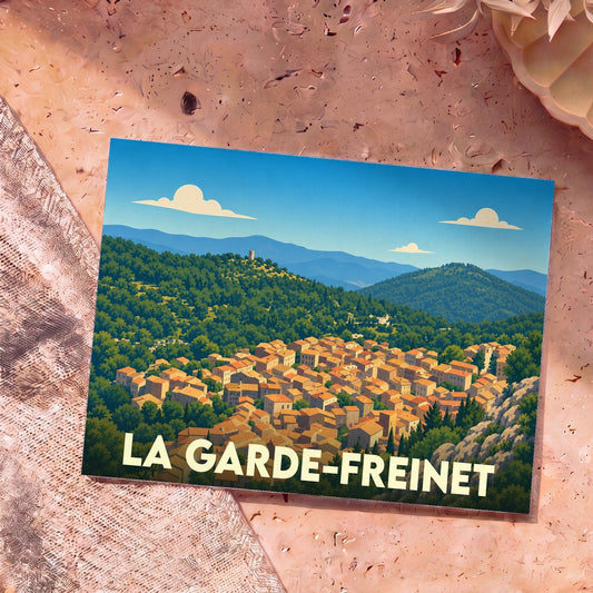 Carte postale souvenir de la ville de La Garde-Freinet avec une illustration stylisée d'un village provençal niché dans des collines boisées.