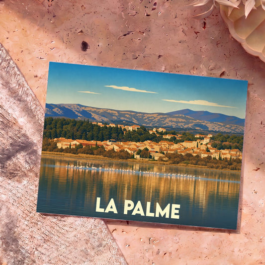 Carte postale souvenir de la ville de La Palme avec une illustration stylisée d'un étang peuplé de flamants roses devant le village.
