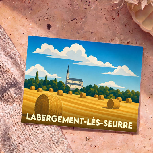 Carte postale souvenir de la ville de Labergement-lès-Seurre avec une illustration stylisée d'un champ de meules de foin devant une église.