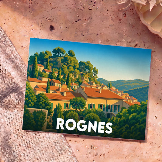 Carte postale souvenir de la ville de Rognes illustrant un village provençal niché dans une colline boisée.