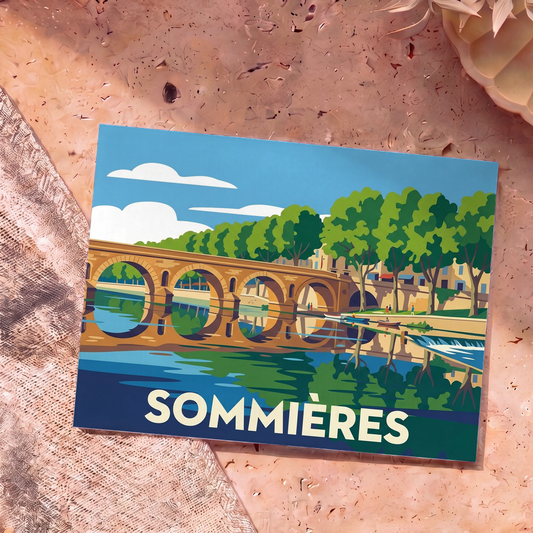 Carte postale souvenir de la ville de Sommières avec une illustration stylisée de son pont romain sur le Vidourle.