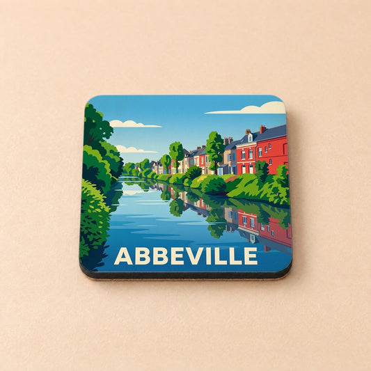 Dessous de verre souvenir de la ville d'Abbeville avec une illustration stylisée d'un canal bordé de maisons colorées.