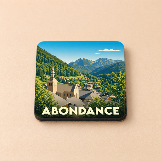 Dessous de verre souvenir de la ville d'Abondance avec une illustration stylisée de son église et des montagnes.