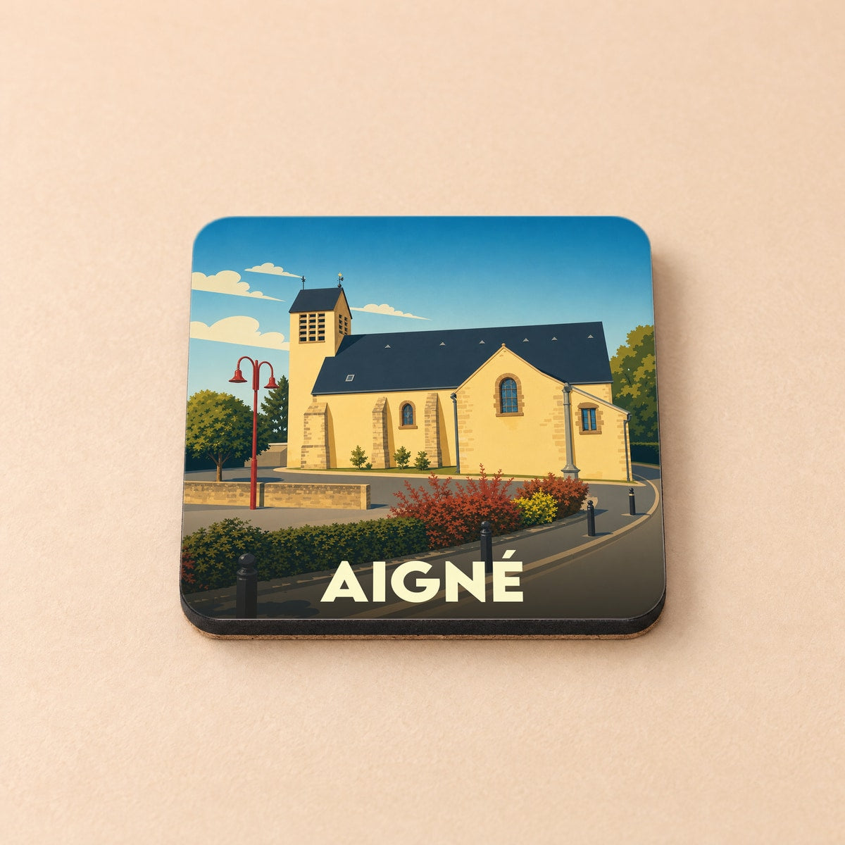 Dessous de verre souvenir de la ville d'Aigné avec une illustration stylisée de son église.