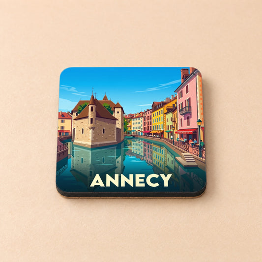 Dessous de verre souvenir de la ville d'Annecy avec une illustration stylisée de son célèbre monument historique au bord de l'eau.