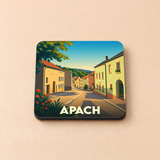 Dessous de verre souvenir de la ville d'Apach illustré d'une rue de village pittoresque.