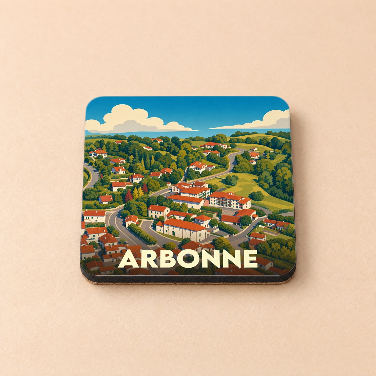 Dessous de verre souvenir de la ville d'Arbonne orné d'une illustration stylisée du village dans un paysage vallonné.