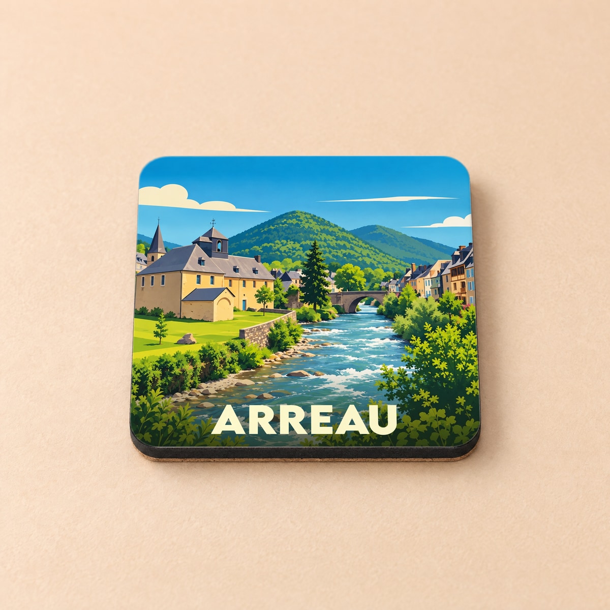 Dessous de verre souvenir de la ville de Arreau illustrant un paysage de montagne traversé par une rivière.