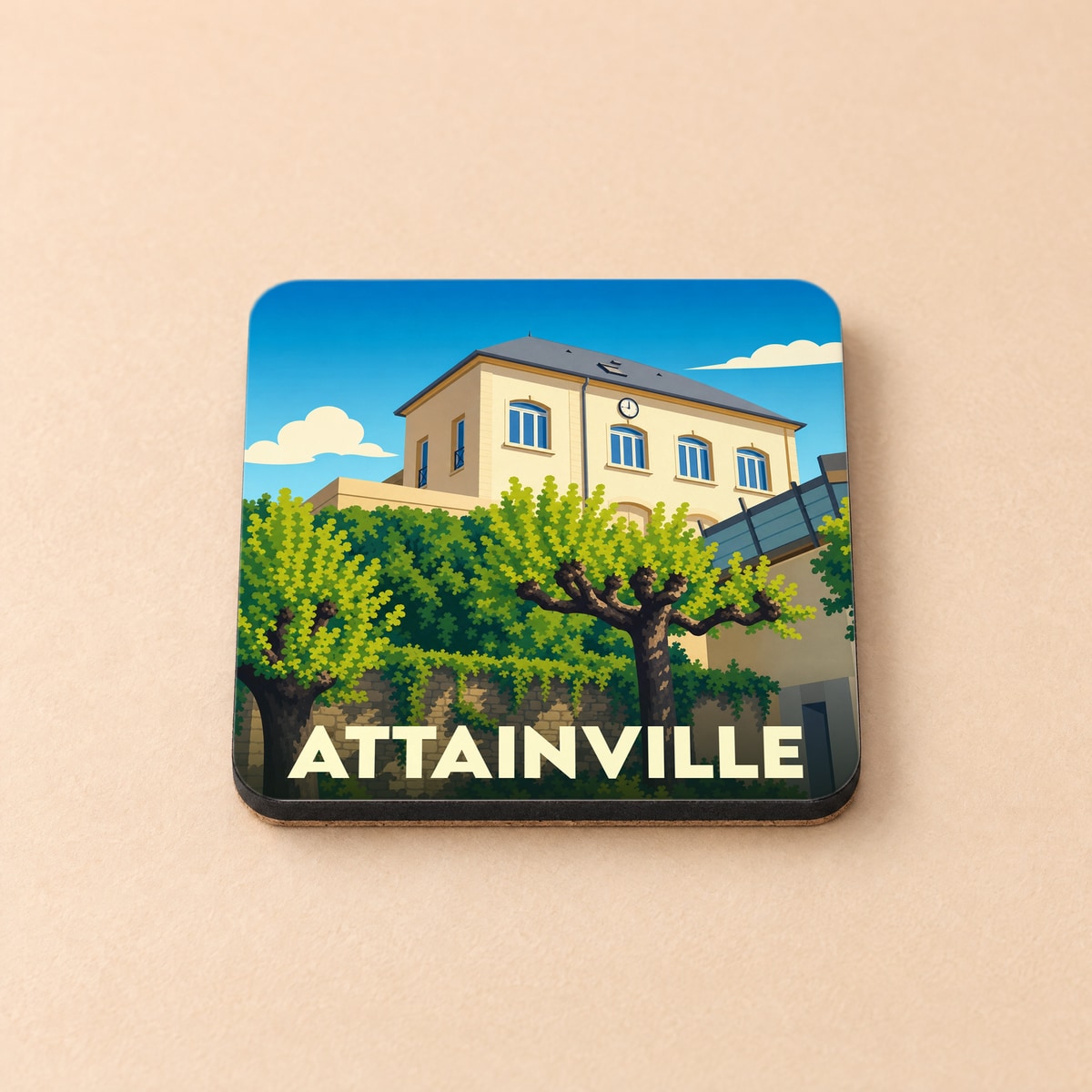 Dessous de verre souvenir de la ville d'Attainville avec une illustration stylisée d'un bâtiment arboré.