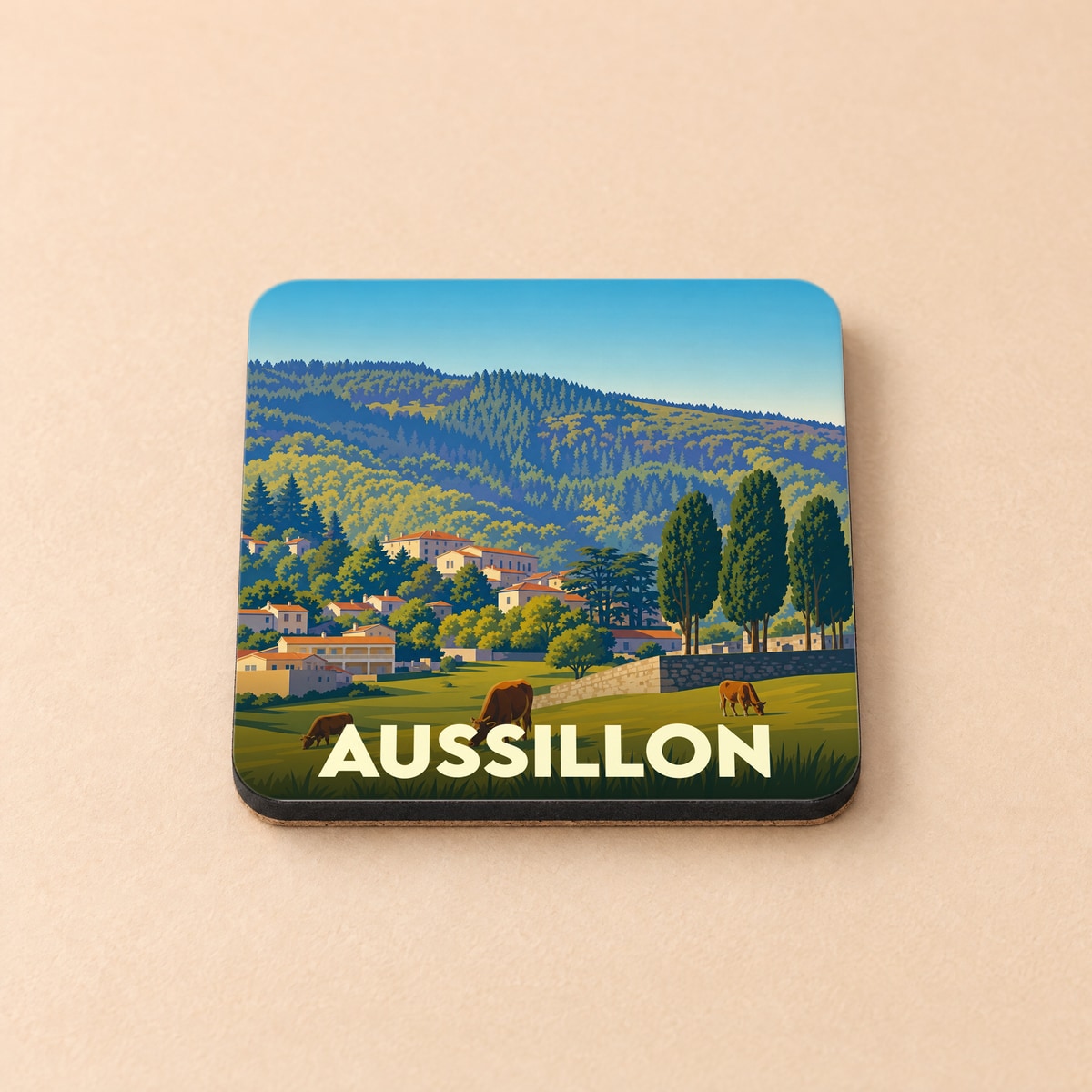 Dessous de verre souvenir de la ville d'Aussillon avec une illustration de paysages vallonnés et de maisons de village.