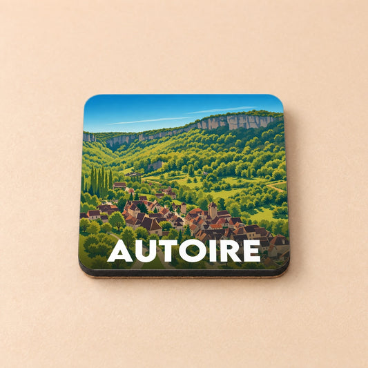 Dessous de verre souvenir de la ville d'Autoire avec une illustration stylisée d'un village niché dans une vallée verdoyante.