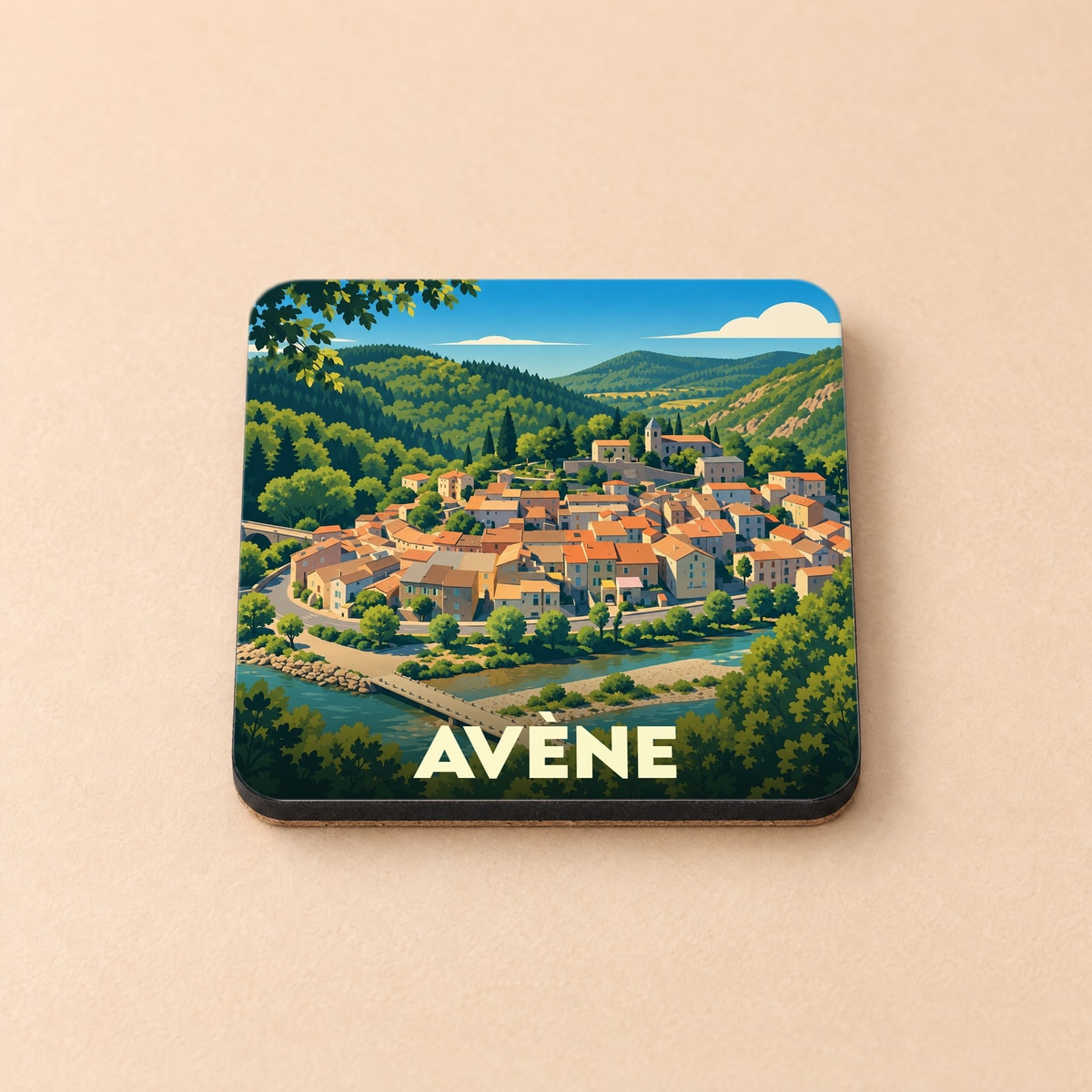 Dessous de verre souvenir de la ville d'Avène avec une illustration stylisée de ses maisons et paysages verdoyants.