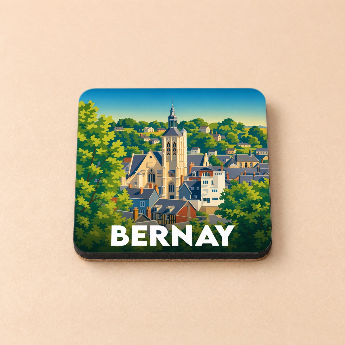 Dessous de verre souvenir de la ville de Bernay avec une illustration stylisée de son église et de ses toits.