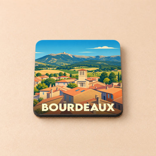 Dessous de verre souvenir de la ville de Bourdeaux avec une illustration stylisée d'un village provençal.