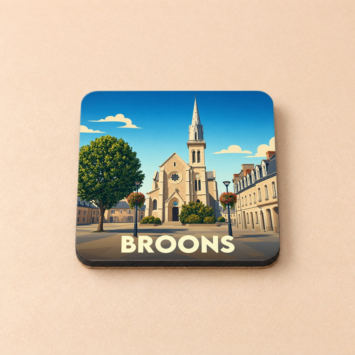 Dessous de verre souvenir de la ville de Broons avec une illustration stylisée de son église et de sa place centrale.