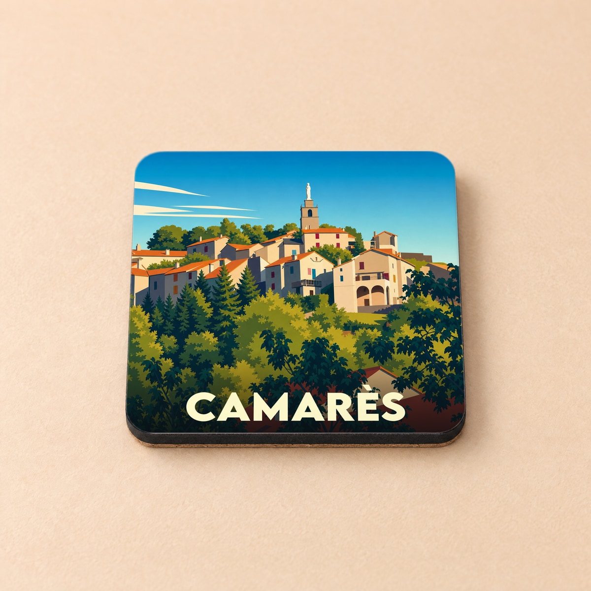 Dessous de verre souvenir de la ville de Camarès avec une illustration stylisée d'un village perché.
