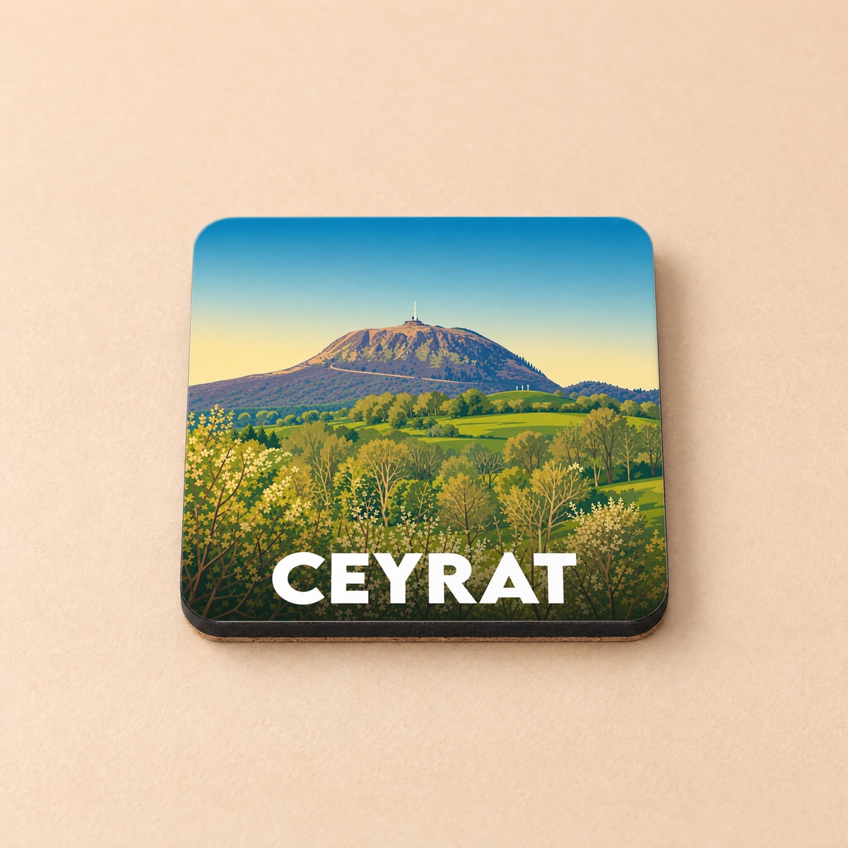Dessous de verre souvenir de la ville de Ceyrat illustrant le Puy de Dôme surplombant une forêt verdoyante.