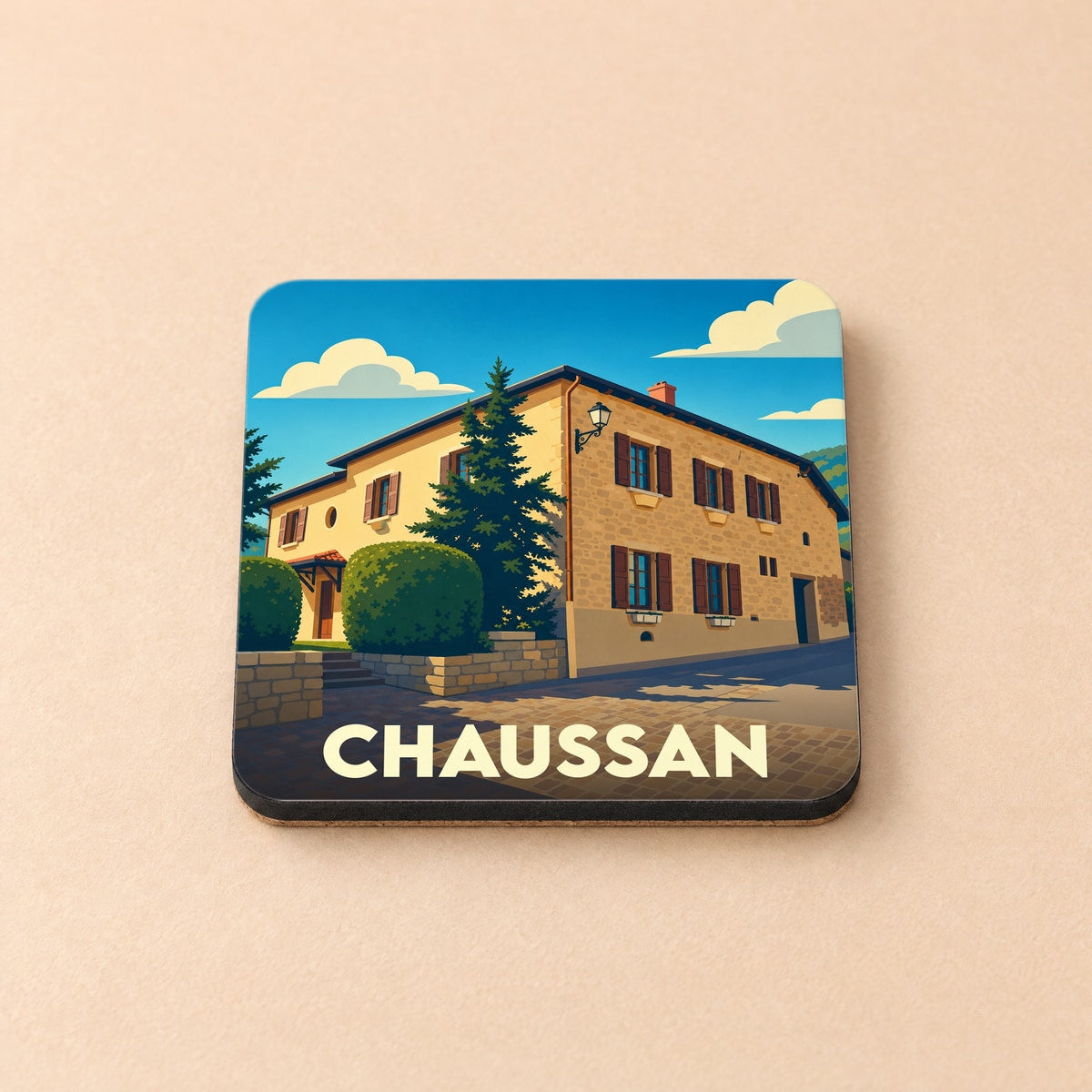 Dessous de verre souvenir de la ville de Chaussan avec une illustration stylisée d'une maison en pierre.