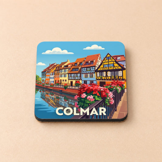 Dessous de verre souvenir de la ville de Colmar illustré de maisons à colombages colorées au bord de l'eau.