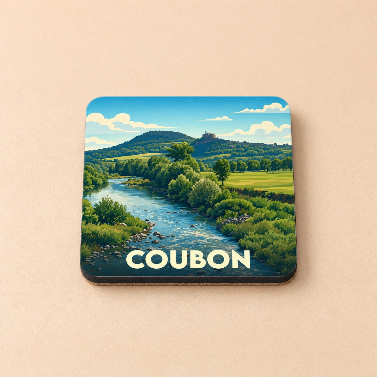 Dessous de verre souvenir de la ville de Coubon avec une illustration stylisée d'un paysage de rivière.