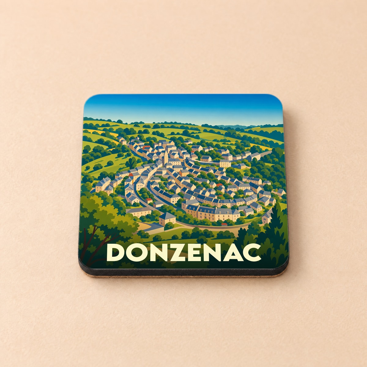 Dessous de verre souvenir de la ville de Donzenac avec une illustration stylisée de ses maisons nichées dans un paysage verdoyant.