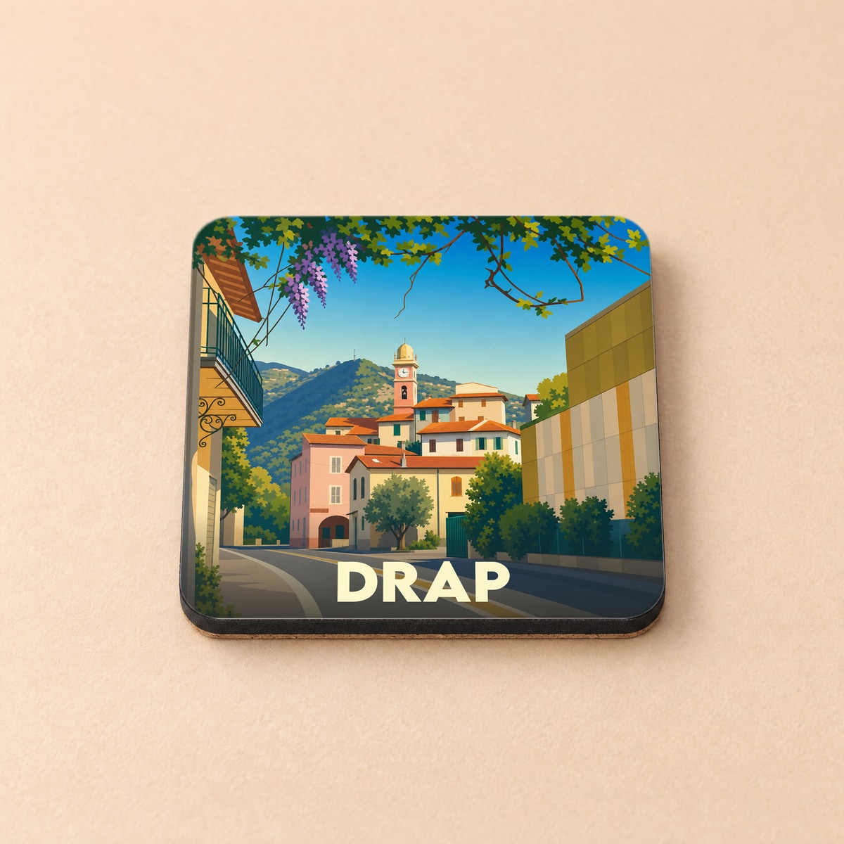 Dessous de verre souvenir de la ville de Drap avec une illustration stylisée d'un paysage urbain provençal.