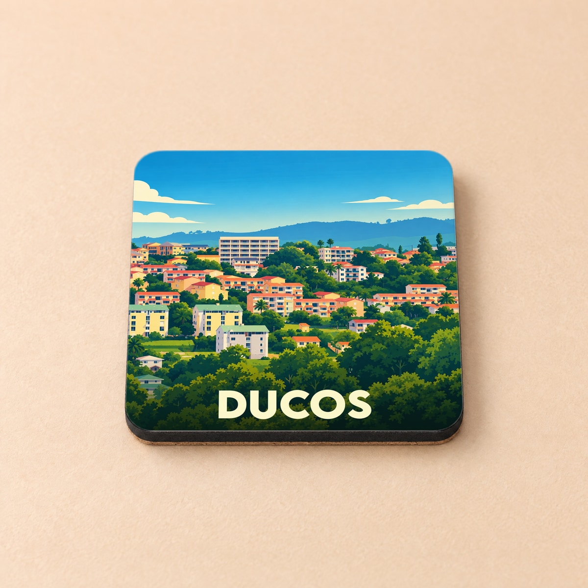 Dessous de verre souvenir de la ville de Ducos avec une illustration stylisée de son paysage urbain verdoyant.
