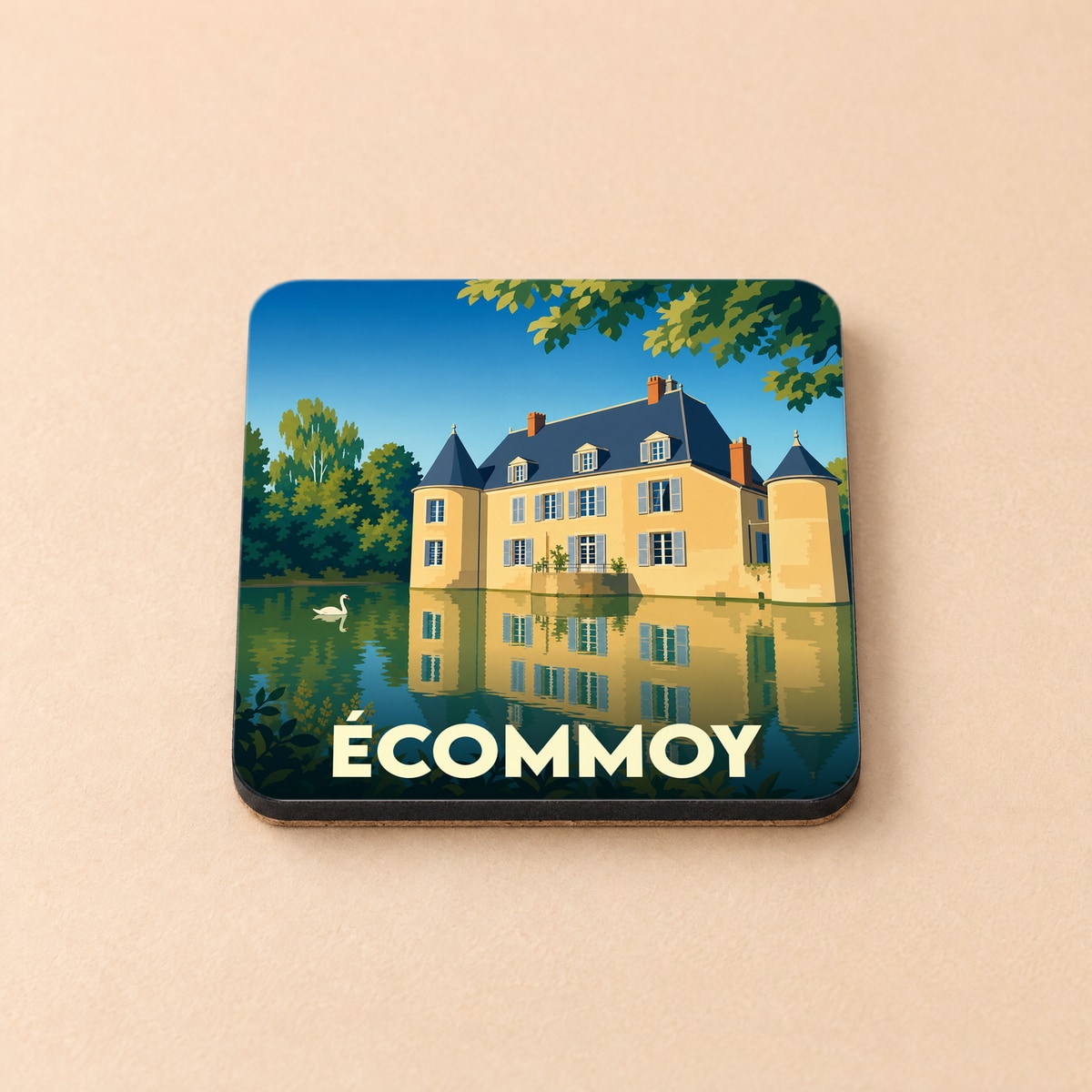 Dessous de verre souvenir de la ville d'Écommoy avec une illustration stylisée d'un château se reflétant dans l'eau.