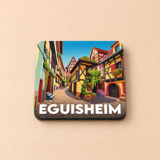 Dessous de verre souvenir de la ville d'Eguisheim avec une illustration colorée de ses maisons à colombages.