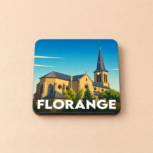 Dessous de verre souvenir de la ville de Florange avec une illustration stylisée de son église sous un ciel bleu.