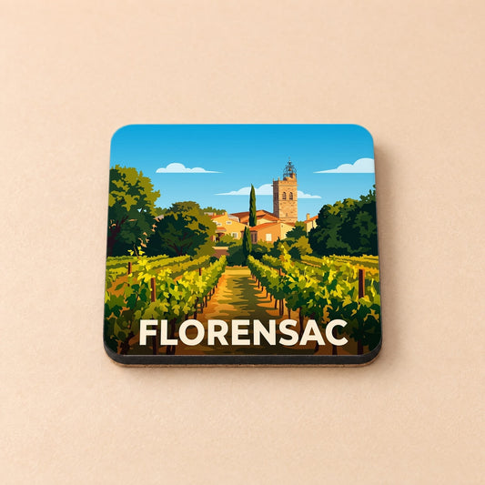 Dessous de verre souvenir de la ville de Florensac illustrant un vignoble devant le village et son clocher.