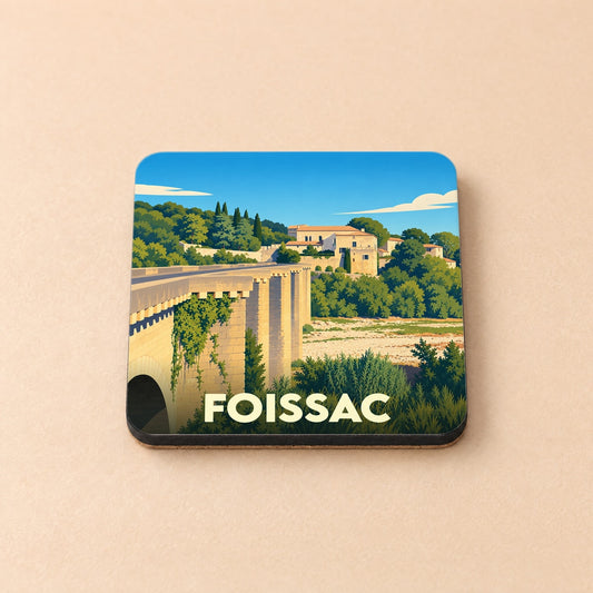 Dessous de verre souvenir de la ville de Foissac avec une illustration stylisée d'un pont de pierre et d'un village provençal.