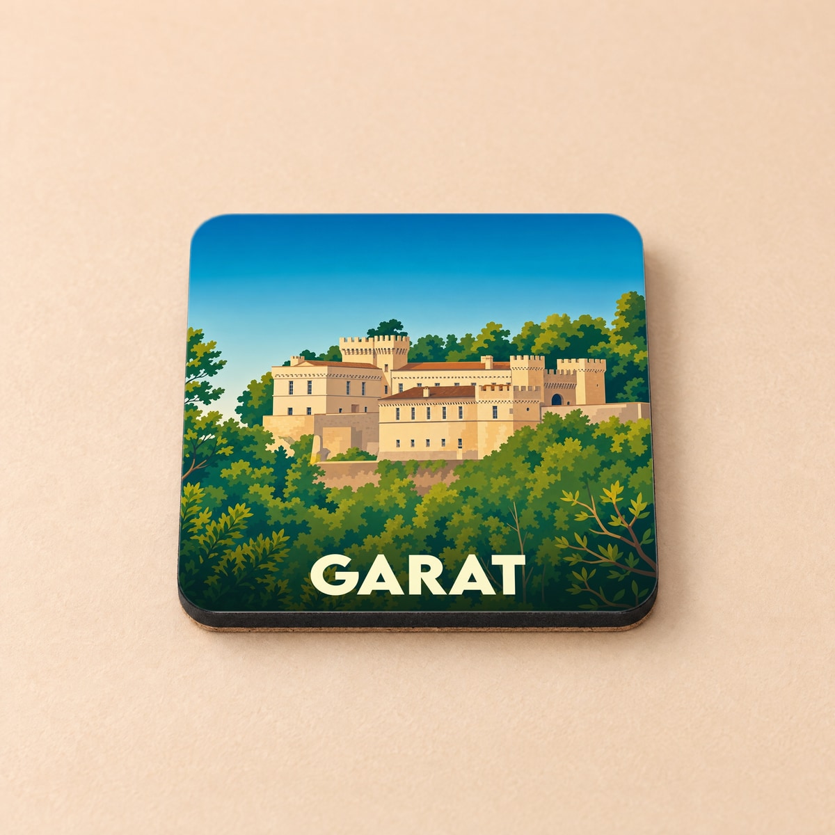 Dessous de verre souvenir de la ville de Garat illustrant son château au milieu d'une forêt verdoyante.