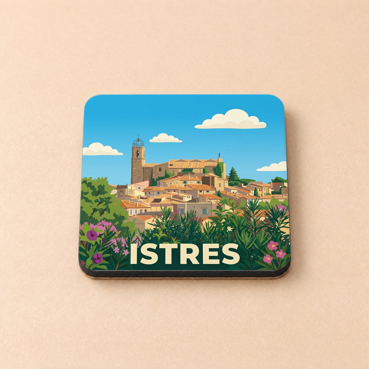 Dessous de verre souvenir de la ville d'Istres avec une illustration stylisée d'un village provençal.