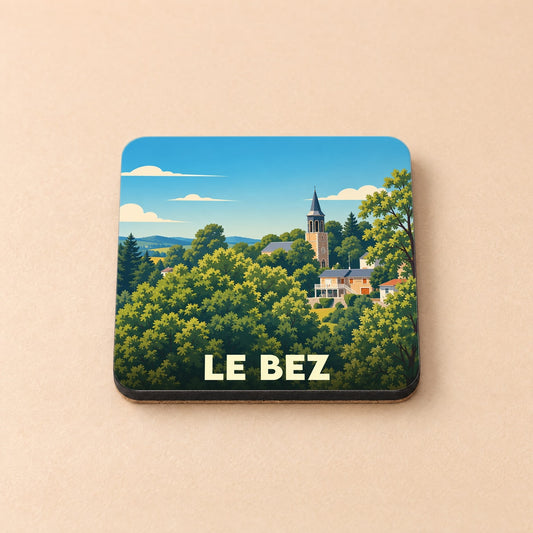 Dessous de verre souvenir de la ville du Bez avec une illustration stylisée d'un village dans un paysage arboré.