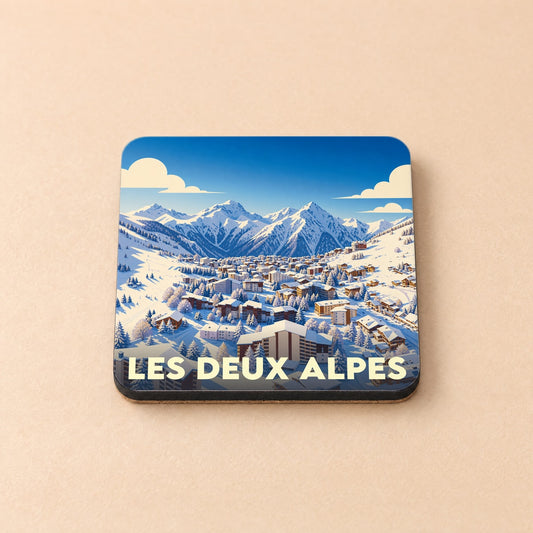 Dessous de verre souvenir de la station Les Deux Alpes avec une illustration stylisée d'un village de montagne enneigé.