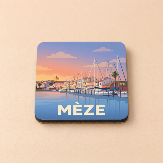 Dessous de verre souvenir de la ville de Mèze avec une illustration stylisée de son port au coucher du soleil.