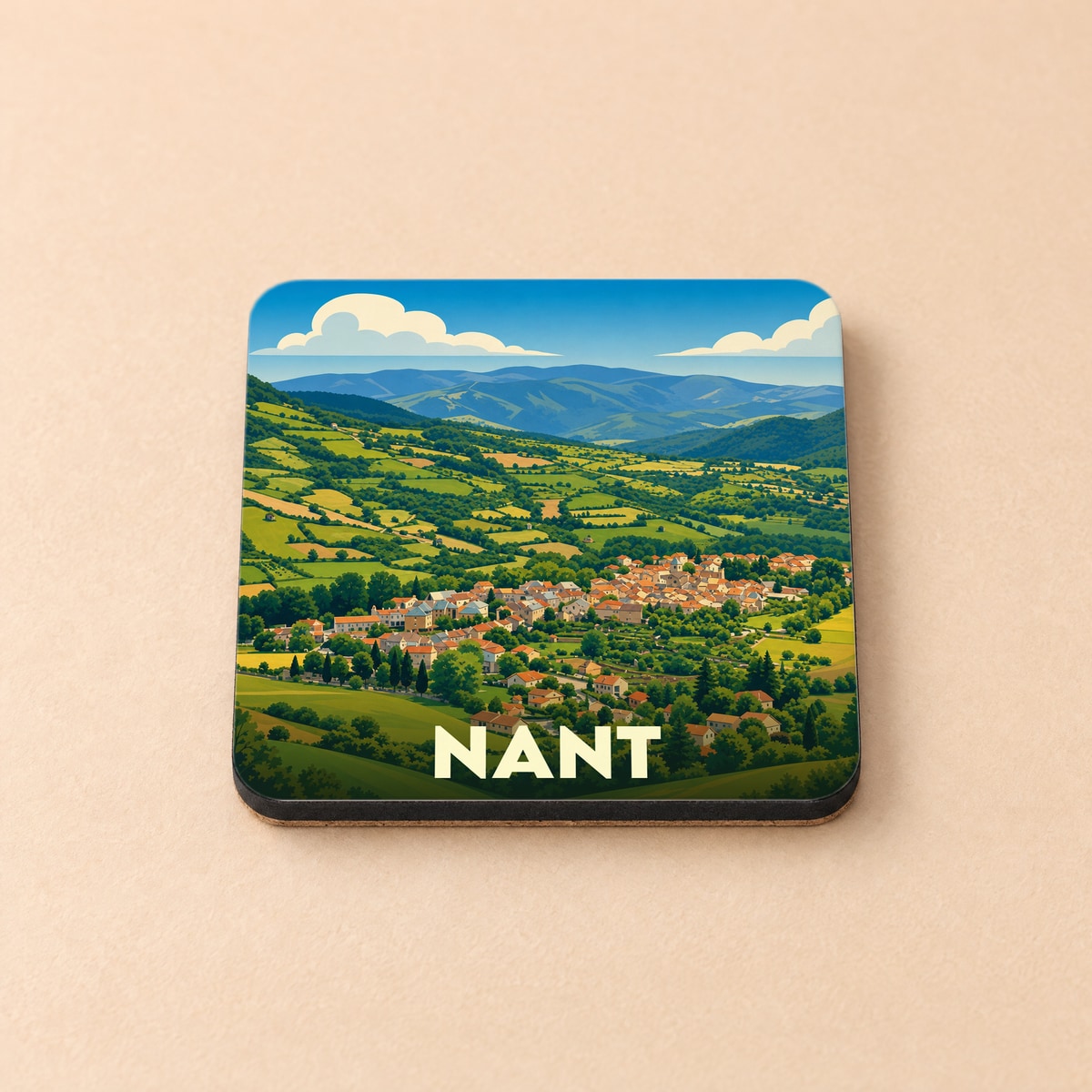 Dessous de verre souvenir de la ville de Nant avec une illustration stylisée d'un paysage de campagne vallonné.